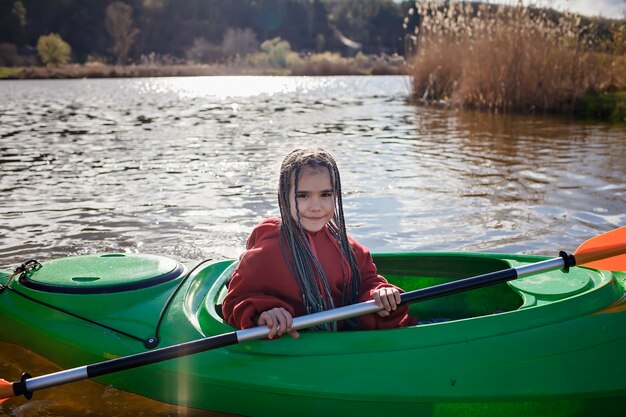 Felice ragazza preteen kayak sulla pagaia del fiume in attività campo estivo mano sport estremo