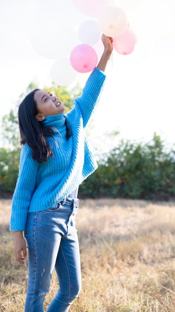 Felice ragazza tenere palloncino al maedow in inverno.