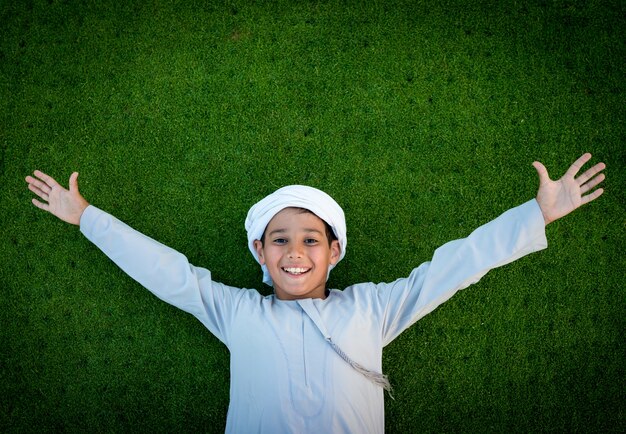 Felice ragazzo arabo su erba verde