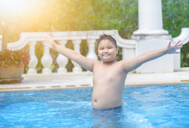 Felice ragazzo grasso obeso in piscina,