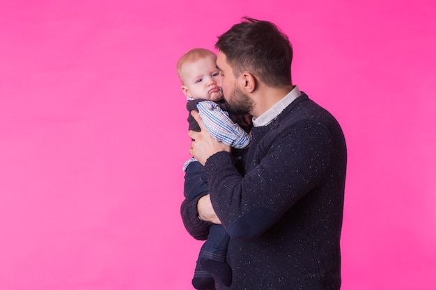 Felice ritratto del padre e del figlio in rosa. In studio.