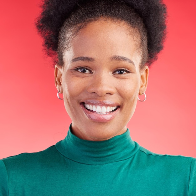Felice ritratto e volto di una donna di colore in studio con un sorriso fiducia e mentalità positiva Trucco naturale di bellezza e persona femminile africana con cosmetici su uno sfondo rosso per il bagliore della pelle