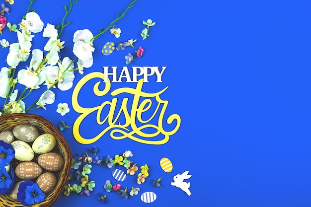 Felice sfondo di Pasqua con nidi di uova e fiori primaverili, sfondo blu e foto vista dall'alto