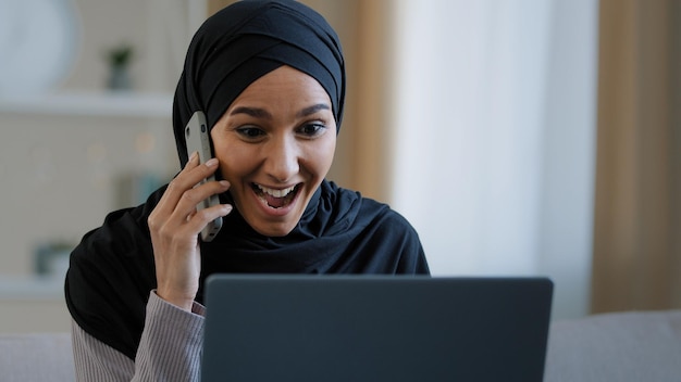 Felice sorridente donna araba ragazza musulmana in hijab libero professionista che parla telefono cellulare rispondendo alla chiamata