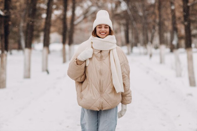 Felice sorridente giovane donna vestita giù giacca sciarpa cappello e guanti gode il tempo invernale e