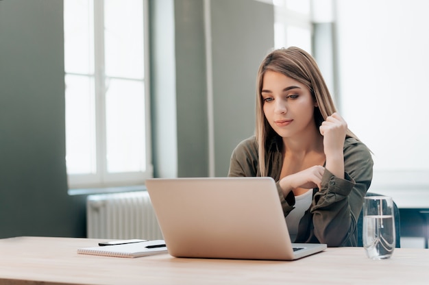 Felice studentessa con un computer portatile e un notebook.