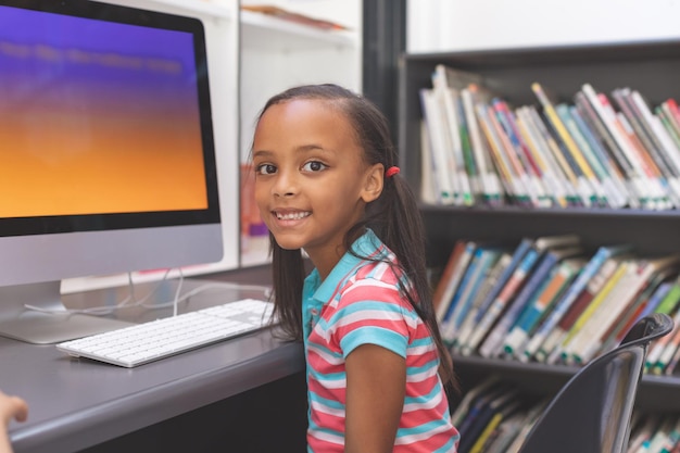 Felice studentessa seduta nella sala computer