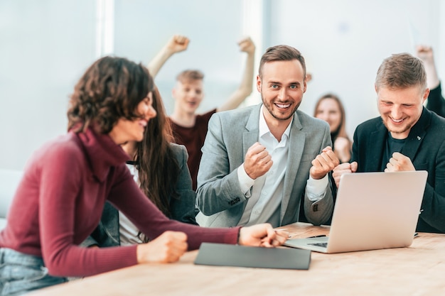 Felice team di dipendenti che guardano lo schermo del laptop