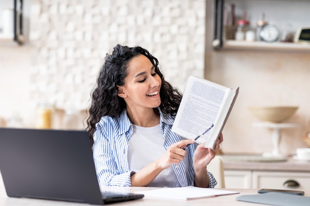 Felice tutor femminile che ha una riunione virtuale tramite laptop dando lezione online da casa seduto