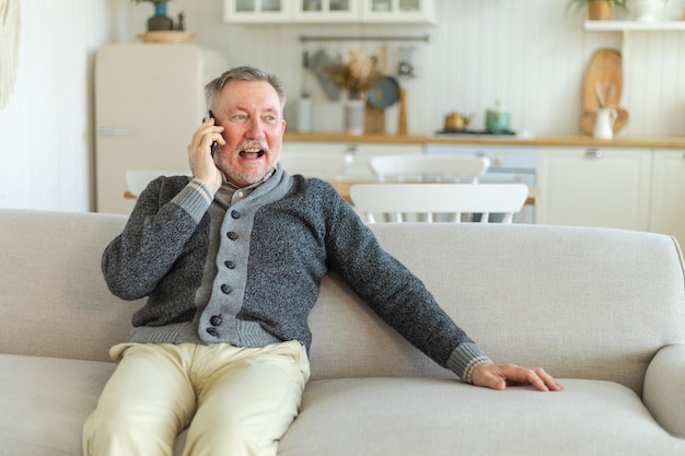 Felice uomo anziano di mezza età che parla su smartphone con amici di famiglia nonno maturo più anziano con