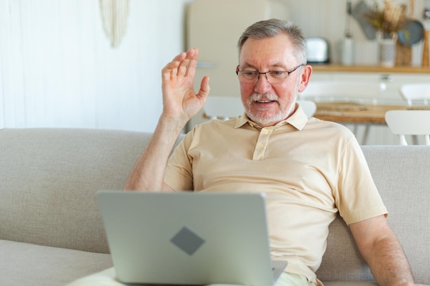 Felice uomo anziano di mezza età con il laptop che parla in videochiamata con la famiglia di amici maturo vecchio senior gr