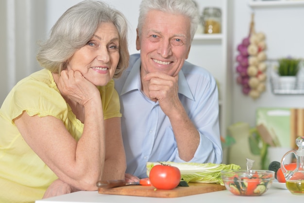 Felice uomo anziano e donna in cucina