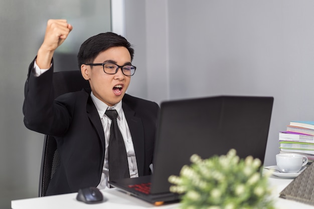 felice uomo d&#39;affari di successo utilizzando il computer portatile