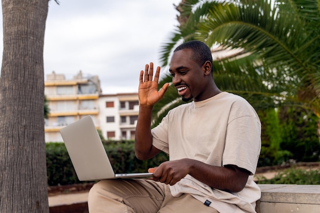 Felice uomo di colore che parla in video chat tramite netbook