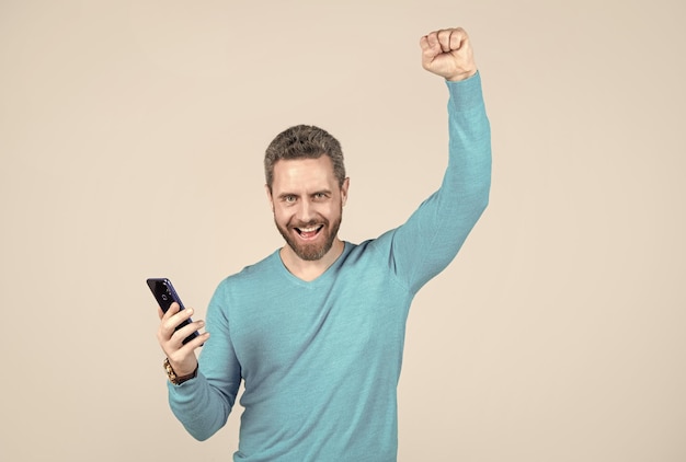 Felice uomo di successo con la barba con successo smartphone