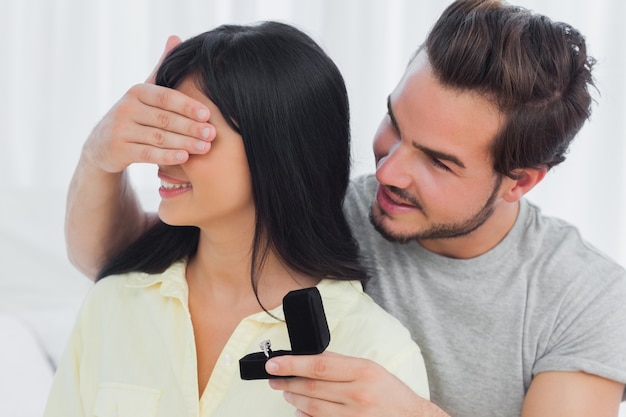 Felice uomo in procinto di proporre gli occhi nascosti della sua ragazza