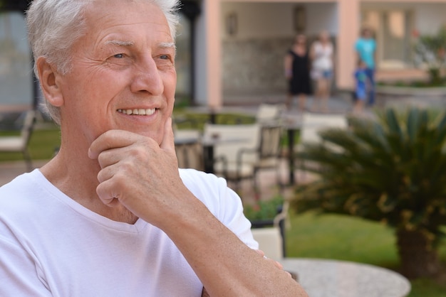 Felice uomo maturo in vacanza pensando e sorridendo