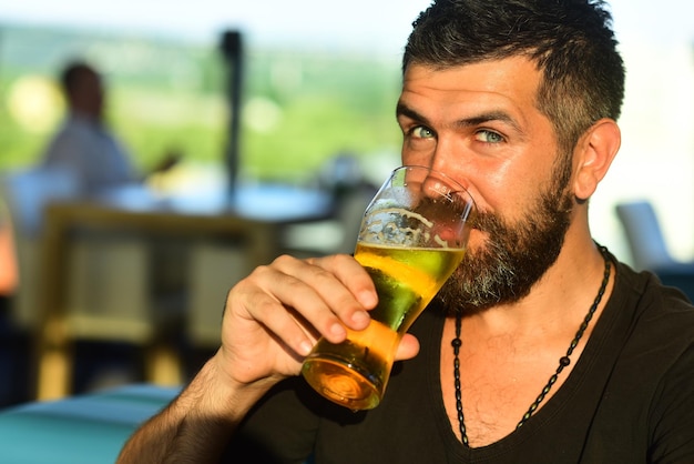 Felice uomo sorridente con birra sexy uomo barbuto sorriso aperto e grande boccale di birra in mano