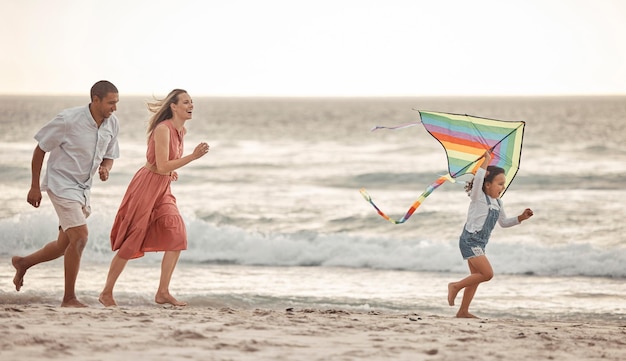 Felice vacanza al mare in famiglia e bambino che fa volare l'aquilone mentre corre in riva al mare con sua madre e suo padre Divertimento energetico e gioco mentre si legano in vacanza e viaggi estivi con uomo donna e bambino