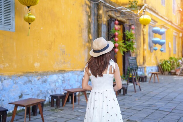 Felice viaggiatore in visita a Hoi An antica città nel Vietnam centrale donna con abito e cappello punto di riferimento in viaggio e popolare per le attrazioni turistiche Vietnam e concetto di viaggio nel sud-est asiatico