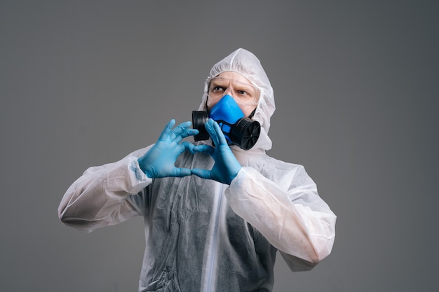 Felice virologo scienziato che indossa abiti protettivi, occhiali e maschera medica