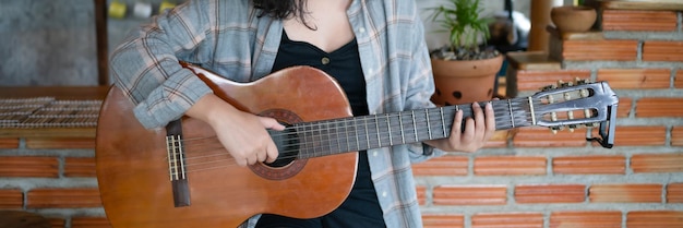 Felici mani di giovane donna che suona la chitarra acustica musicista da solo compone lezioni di canzoni strumentali su come suonare la chitara