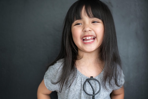 Felicità capelli neri asiatico grande occhio ragazza ritratto servizio fotografico con abito casual con divertimento su sfondo nero dello schermo