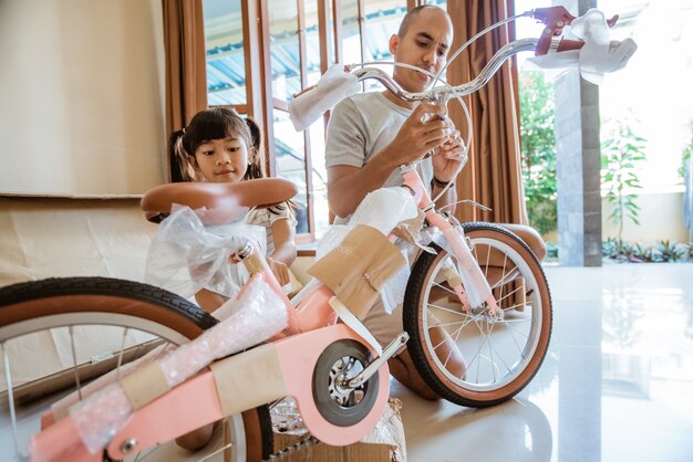 Felicità delle figlie quando scartano una nuova mini bici