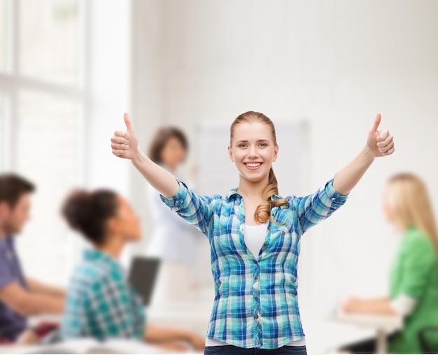 felicità e concetto di persone - ragazza sorridente in abiti casual che mostrano i pollici in su