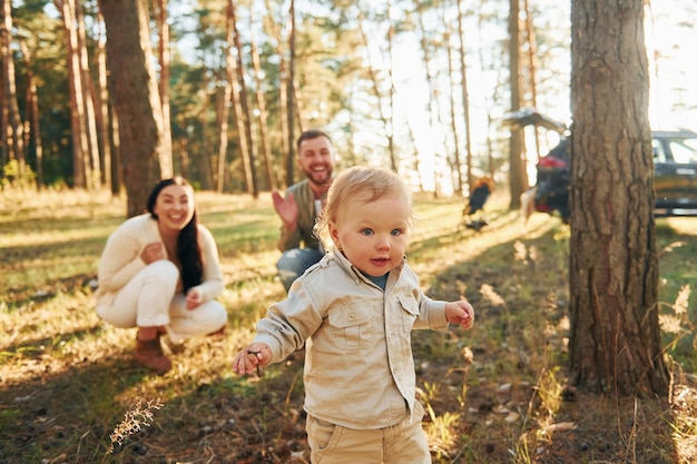 Felicità estiva La famiglia di padre, madre e figlia piccola è nella foresta