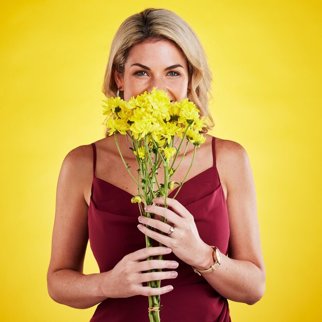 Felicità ritratto e donna annusare fiori in studio isolato su uno sfondo giallo Bouquet floreale e persona femminile annusare aroma o profumo di piante naturali e fiori freschi per la primavera