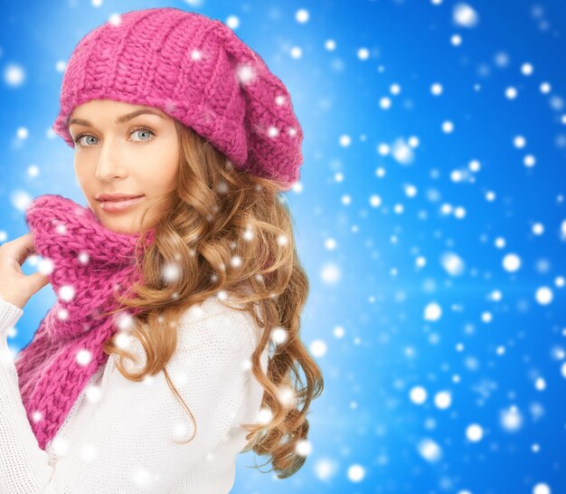 felicità, vacanze invernali, natale e concetto di persone - giovane donna con cappello rosa e sciarpa su sfondo blu innevato