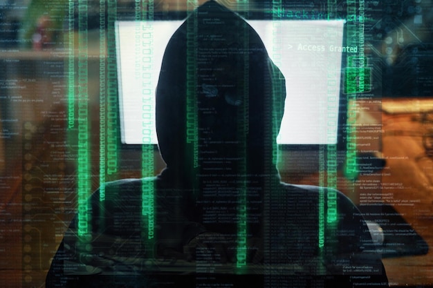 Felpa con cappuccio uomo hacker e schermo del computer per codifica o programmazione di hacking software di notte in sovrapposizione digitale Codice dati html e programmatore o persona hacker da dietro sicurezza informatica e desktop