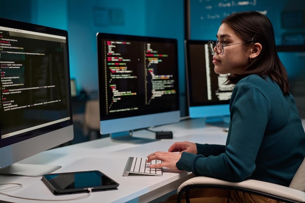 female computer programmer typing at keyboard