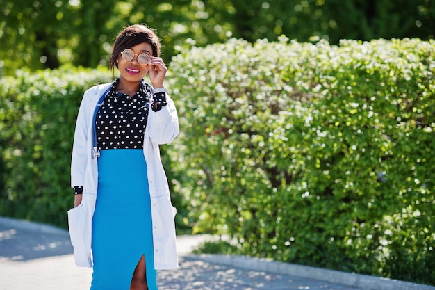 Femmina afroamericana del medico con lo stetoscopio poste all'aperto