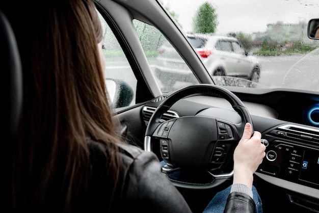 Femmina alla guida di un'auto in caso di pioggia.