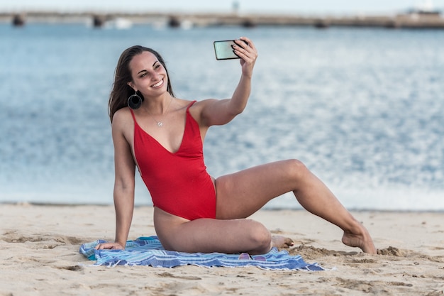 Femmina allegra che prende selfie vicino al mare