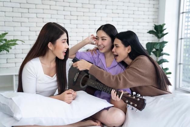 femmina asiatica che suona la chitarra in camera da letto