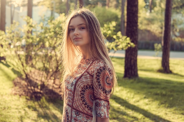 Femmina castana dai capelli lunghi sveglia in un parco di autunno.