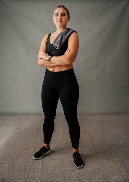 Femmina caucasica tonica in piedi con le braccia incrociate pronte per allenarsi