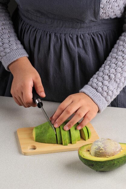 Femmina che affetta l'avocado maturo