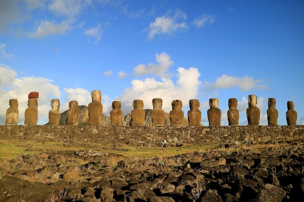 Femmina che scatta foto sul retro di 15 statue Moai del sito di Ahu Tongariki sull'isola di Pasqua Cile