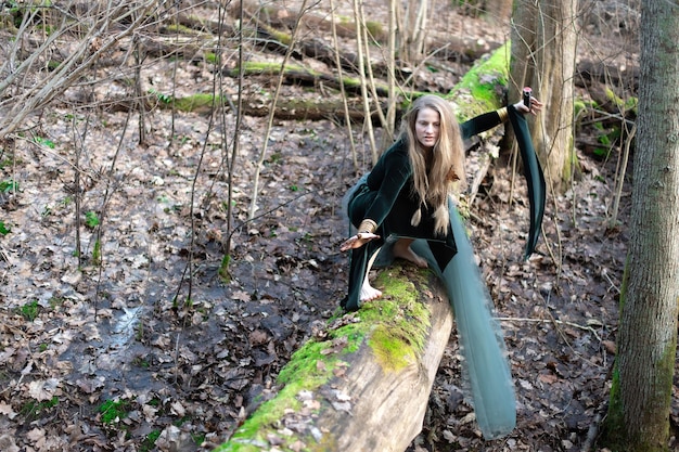 Femmina che tiene in mano una bomba a fumo sul tronco di un muschio verde all'inizio della primavera