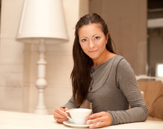 Femmina che tiene una tazza di caffè