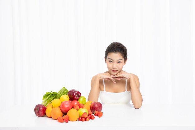 Femmina con frutta fresca sul tavolo isolata su sfondo bianco dieta concept