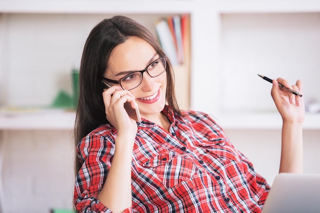 Femmina europea utilizzando laptop e telefono