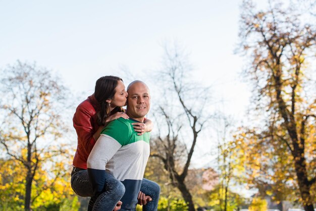 Femmina Sorridente Portante Maschio Sulla Schiena Al Parco