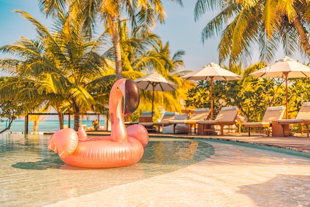 Fenicottero rosa gonfiabile della piscina del turismo estivo, hotel resort di lusso a bordo piscina. Buon tramonto