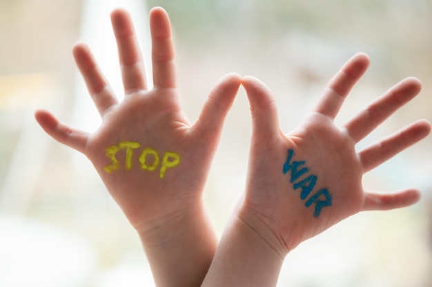 Fermare il segno di guerra scritto sui palmi di un bambino