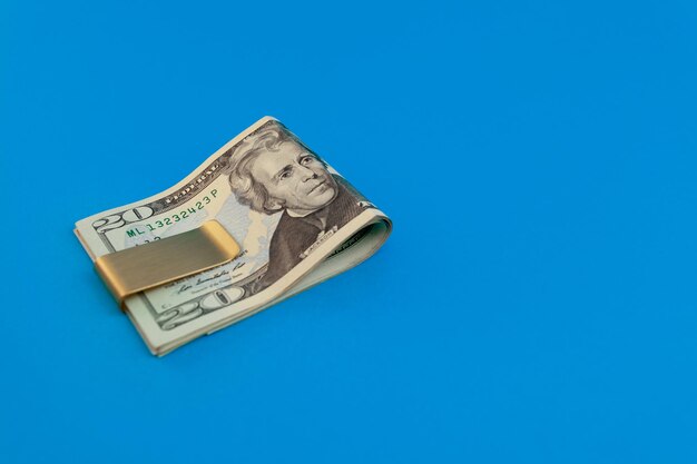Fermasoldi con banconote da un dollaro su sfondo blu
